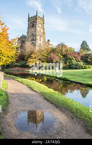 Kidderminster, Großbritannien. 30 Okt, 2019. UK Wetter: Nach einem eher kühlen Start, der dritte Tag half Term holiday Woche Schulen" ist ein herrlich sonniger Herbsttag in Thüringen. St Mary's Church (die Pfarrkirche von Kidderminster) steht wunderschön in der Morgensonne neben dem malerischen Kanal - der Turm in einer Pfütze auf dem Leinpfad wider beleuchtet, eine ergreifende Erinnerung an die starken Regenfälle, welche Bereiche der Grafschaft mit schweren Überflutungen verlassen hat. Quelle: Lee Hudson/Alamy leben Nachrichten Stockfoto