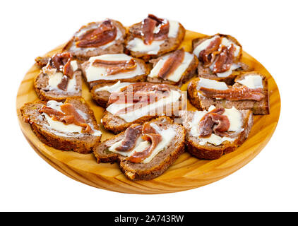 Leckere Scheiben Brot mit Butter und gesalzene Sardellenfilets. Traditionelle Spanische Küche Fisch Tapas. Auf weissem Hintergrund Stockfoto