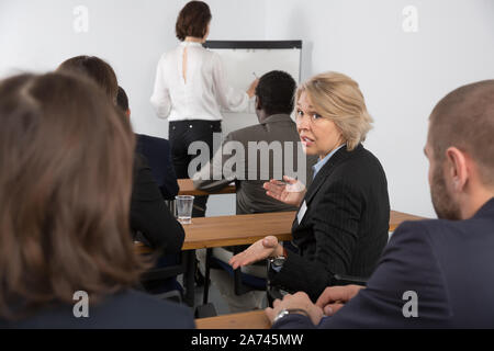 Ältere Frau, was die anderen Teilnehmer während Business Seminar Stockfoto