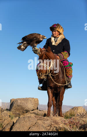 Alte traditionelle kasachische eagle Jäger mit seinem goldenen Adler in den Bergen posieren. Ulgii, der westlichen Mongolei. Stockfoto