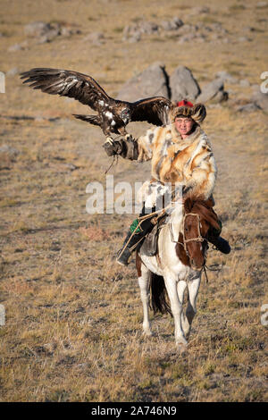 Alte traditionelle kasachische eagle Jäger mit seinem goldenen Adler in den Bergen posieren. Ulgii, der westlichen Mongolei. Stockfoto