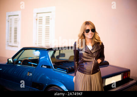 Portrait von glücklichen Frau, die neben ihrem Auto und Lachen. Stockfoto