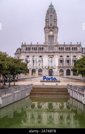 Die Kommunalen do Porto am frühen Morgen mit der Reflexion des historischen Gebäudes im Teich im Vordergrund. Stockfoto