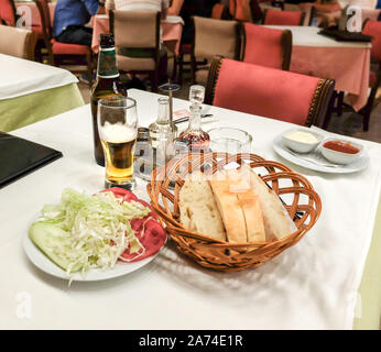 An ein Restaurant in Montenegros Hauptstadt. mit Salat Dressing, Olivenöl, mayonaisse, Salz, Pfeffer, Ketchup und Bier. Stockfoto