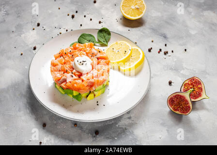 Köstliche avocado und gesalzenen Lachs Tatar auf konkreten Hintergrund Stockfoto