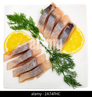 Marinierter Hering Filet mit in Scheiben geschnittenen Zitrone und Dill, gesundes Essen. Auf weissem Hintergrund Stockfoto