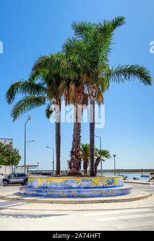 Palmen Palmen am Meer und Promenade in Santa Luzia gegen die Ria Formosa. Santa Luzia Algarve, Portugal. Stockfoto