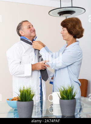 Portrait von positiven reife Frau zu Mann und Einstellen der Riegel zu Hause Stockfoto