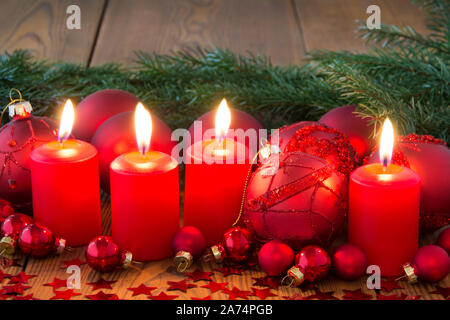 Adventskranz mit brennenden Kerzen und Holz- Hintergrund Stockfoto