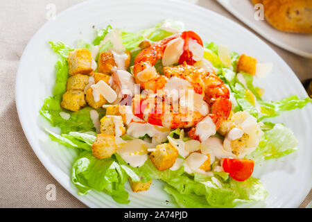 Pikante Caesar Salat mit grünem Salat, knusprigen Croutons, Parmesan und gegrillte Garnelen Stockfoto