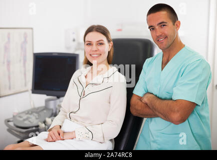 Portrait von lächelnden Arzt und Patient im Ultraschall Diagnose Zimmer im modernen Klinik Stockfoto