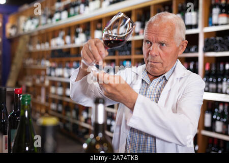 Portrait von älteren Mann professioneller Sommelier Weinprobe Rotweine im Weingut Stockfoto