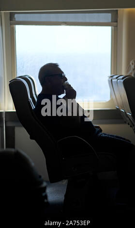 Ein Mann essen auf einem Blue Star Fähre. Stockfoto