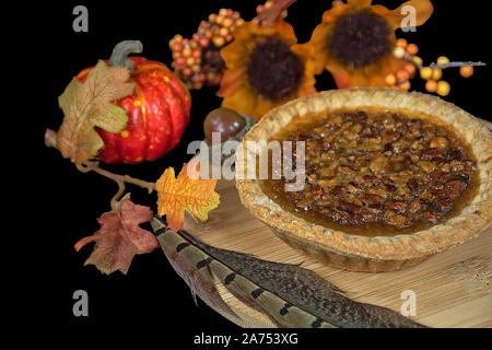 Pecan Pie mit Fasan mit Feder und Blätter im Herbst auf Holz Stockfoto