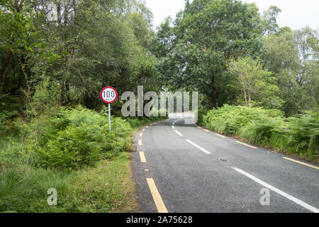 100 km und Stunde Höchstgeschwindigkeit auf eine irische Country Road Green Lane mit einer gefährlichen Kurve Stockfoto