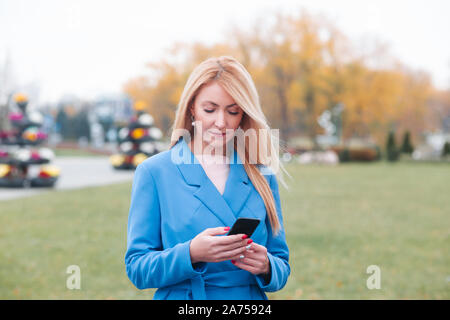 Portrait reife Geschäftsfrauen im blauen Anzug mit Smartphone in der Stadt Stockfoto