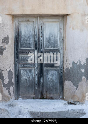 Verwitterte Black Dark Grey grau Holz alte Tür mit Panels und Getreide durch alte Lackierung Santorini Stockfoto