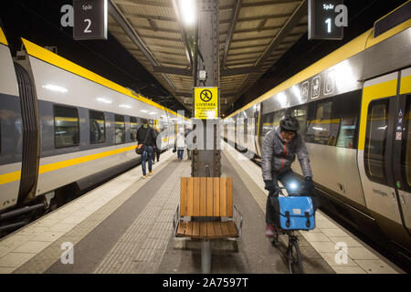 Göteborg, Schweden. 23 Okt, 2019. Ein Radfahrer fährt in zwischen den Zügen auf dem Göteborger Hauptbahnhof. Die Station dient 27 Millionen Passagieren pro Jahr und ist damit der zweitgrößte Bahnhof in Schweden. Credit: Karol Serewis/SOPA Images/ZUMA Draht/Alamy leben Nachrichten Stockfoto