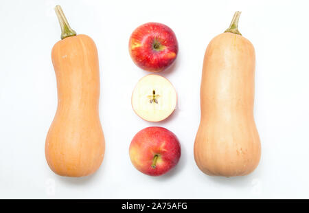 Zwei Kürbisse und 3 ganze Äpfel und Scheiben auf einem weißen Hintergrund. Zutaten für Ernährung Salat oder frisch gepressten Saft. Stockfoto