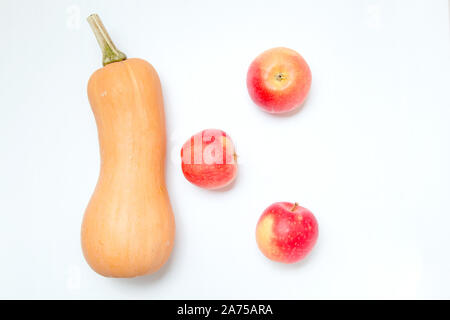 Ein Kürbis und drei Äpfel auf einem weißen Hintergrund. Zutaten für Ernährung Salat oder frisch gepressten Saft. Stockfoto