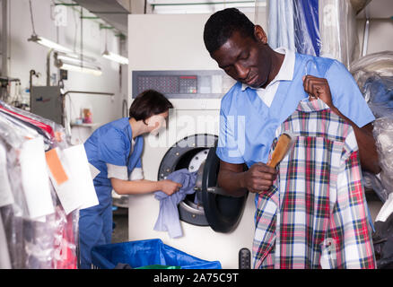 Erfahrene Afrikaner - Mann bei der Arbeit in der modernen Reinigung Stockfoto