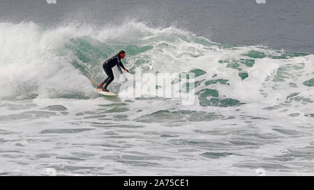 Surfer Reiten eine große Welle an Fistral Beach, Newquay, Cornwall. Stockfoto