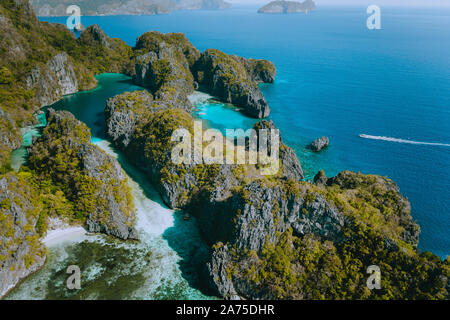 Luftaufnahme von einer einzigartigen Blauen Lagune von zerklüfteten Kalksteinfelsen auf tropischen von Miniloc Island, El Nido, Palawan, Philippinen umgeben Stockfoto