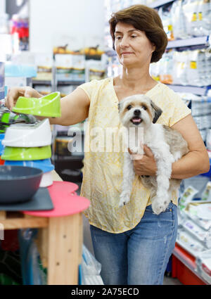 Froh, Frau besuchen Pet Shop auf der Suche nach Dog Bowl für die Fütterung Ihres süssen Havaneser Stockfoto
