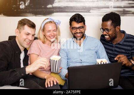 Gerne diverse Freunde Studenten Gruppe unter Laptop mit Spaß, sich die Komödie, online zeigen, lustige Video. Multirassischen junge Menschen lachen u Stockfoto