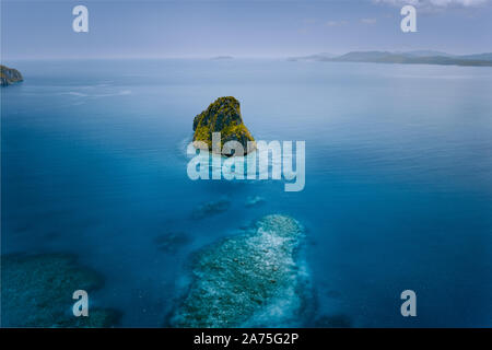 Antenne Drohne auf einem wunderschönen einsamen surreale Cliff Insel von Azure türkisblauen Ozean Wasser umgeben. Bacuit Archipel ist eines der Besten Stockfoto