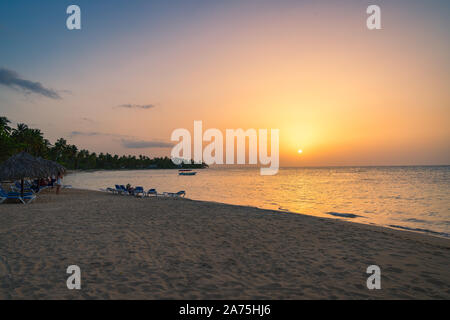 Landschaft von Paradise Tropical Island Strand mit Touristen am Strand und Yacht Hintergrund, Sonnenuntergang Schuß an die Dominikanische Republik, Grand Bahia Principe bea Stockfoto