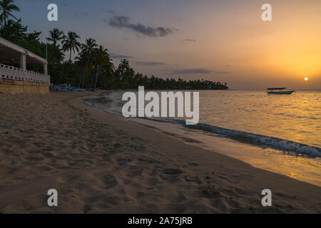 Landschaft von Paradise Tropical Island Strand mit Boot Hintergrund, Sonnenuntergang Schuß an die Dominikanische Republik, Grand Bahia Principe Beach. Stockfoto