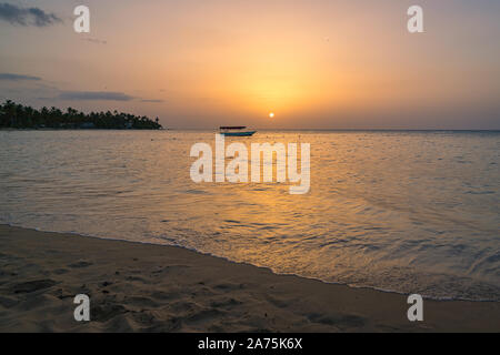 Landschaft von Paradise Tropical Island Strand mit Boot Hintergrund, Sonnenuntergang Schuß an die Dominikanische Republik, Grand Bahia Principe Beach. Stockfoto