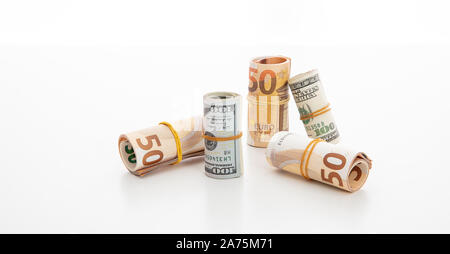 Geld, Finanzen Konzept. Usd- und Euro-Banknote Brötchen, amerikanischen und europäischen Währung vor weißem Hintergrund. Stockfoto