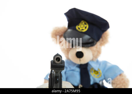 Polizei und Waffen Konzept. Niedlichen Teddybären in Polizeioffizier einheitliche Holding Pistole vor weißem Hintergrund Stockfoto