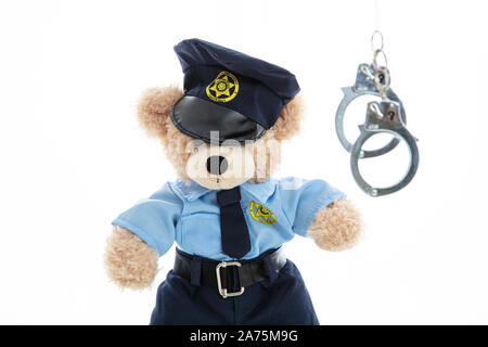 Polizei und Verhaftung Konzept. Niedlichen Teddybären in Polizeioffizier einheitliche und Handschellen vor weißem Hintergrund Stockfoto