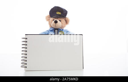 Polizei und Ticket Konzept. Niedlichen Teddybären in Polizeioffizier einheitliche Holding ein leeres Pad vor weißem Hintergrund, kopieren Raum Stockfoto