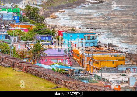 Bunte Häuser führen am Hang über den Blick auf den Strand in San Juan, Puerto Rico Stockfoto