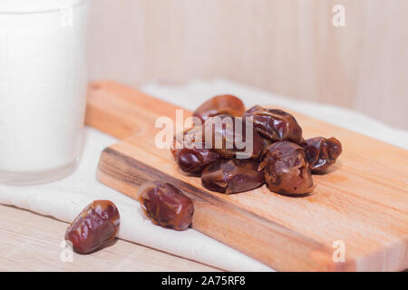 Getrocknete Datteln, Milch auf Stoff Hintergrund. Konzept. Termine Holzbrett. Vegetarisches Essen. Kopieren Sie Platz. Closeup Hintergrund Stockfoto