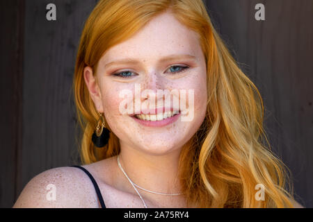 Porträt einer wunderschönen Lächeln junges Mädchen mit roten Haaren und Sommersprossen Stockfoto