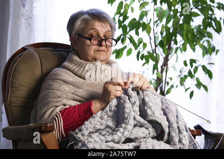 Nahaufnahme Porträt der älteren Frau Stricken mit Wolle, Großmütter Hände Stricken Wolle Garn. Handwerk Hobby von alten Frauen. Ältere Dame, glückliche Oma Knitte Stockfoto