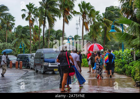 Paradise Island, Bahamas - September 21,2019: Touristische und Tour Vans und Führer zu Fuß und stehen im Regen vor dem Hotel Atlantis Resort. Stockfoto