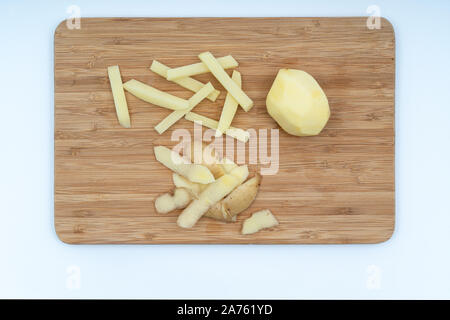 Eine Kartoffel geschält und in einem Stock, auf einer Holzplatte ausschneiden Stockfoto