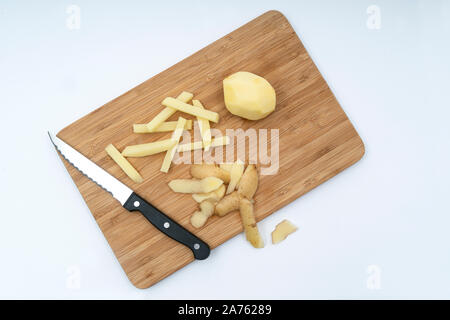 Eine Kartoffel geschält und in einem Stock, auf einer Holzplatte ausschneiden Stockfoto