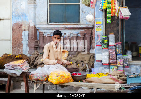 Jodhpur, Indien - 28. Februar, 2018: Ein indischer Hersteller warten auf Kunden außerhalb seines speichern. Stockfoto