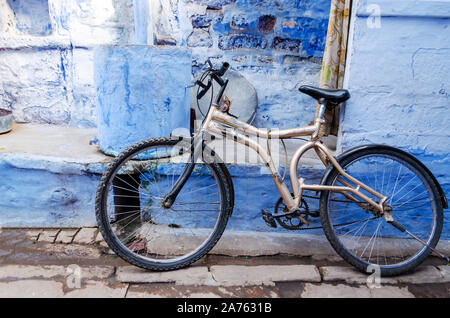 Altes Fahrrad gegen einen alten blauen bemalte Wand lehnt Stockfoto