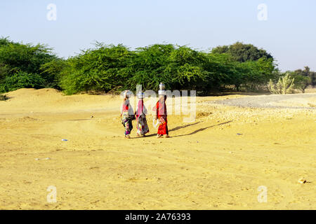 Jaisalmer, Indien - 27. Februar 2018: Indische Damen mit einem Eimer Wasser in der Nähe der Wüste Thar. Stockfoto