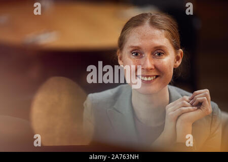 Portrait von erfolgreichen roten Haaren Geschäftsfrau, Lächeln auf die Kamera beim Sitzen im Büro Stockfoto