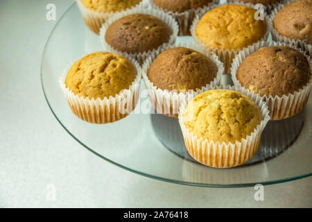 Muffins in Formen auf einem Glas runde Platte Stockfoto