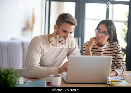 Frau Brille im Gespräch mit Ehemann während der Arbeiten von einem Remotestandort aus Stockfoto